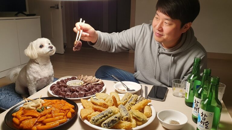 A person trying to feed soondae (Korean blood sausage) to a dog